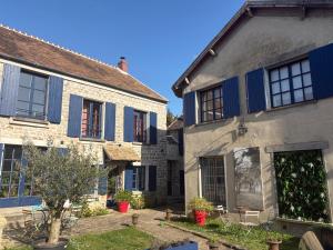 two old stone houses with blue shutters on them at ARTEMIS GÎTE in Barbizon