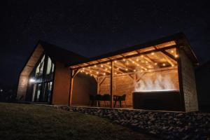 a house lit up at night with lights at Górska Stodoła - Domek z Prywatnym Jacuzzi in Lipowa