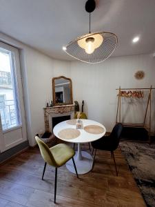 a dining room with a table and chairs and a mirror at Le Repaire blterrois in Béziers