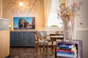 a living room with a tv and a table with chairs at Hotel Le Lampare in Caorle