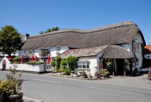a building with a thatched roof on a street at 5 Bed in Croyde oc-croydb in Croyde