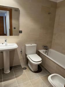 a bathroom with a toilet and a sink and a bath tub at El rincon del Cares in Panes