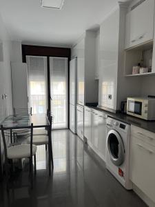 a kitchen with a table and a washing machine at El rincon del Cares in Panes