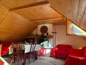 a dining room with a table and red chairs at La mansarda in Santa Maria Maggiore