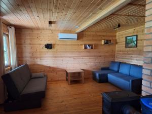 a living room with two blue couches and a table at Pod Dębem in Winnica