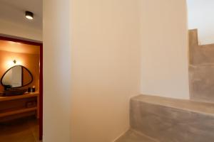 a bathroom with a white wall and a mirror at Arbarorisa Traditional Suites in Mesaria +117 photos