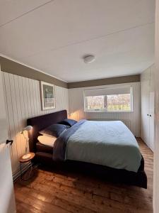 a bedroom with a large bed and a window at Beach Hangout Hygge in Den Burg