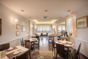 a restaurant with tables and chairs in a room at Hotel Le Lampare in Caorle