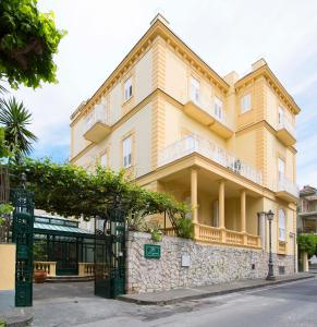 a yellow building with a gate in front of it at Hotel Crawford in Sant'Agnello