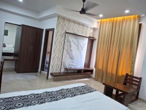 a bedroom with a bed and a desk and a mirror at The Rustic Inn Kaziranga in Kāziranga