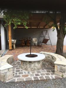 a stone patio with a table and a tree at Dombi Porta in Erdőbénye
