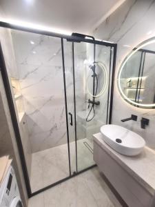 a bathroom with a glass shower and a sink at TARNO Lake Apartment in Tarnobrzeg