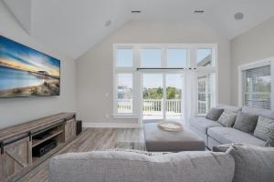 a living room with a couch and a tv at 4918 - Stress Less in Kitty Hawk