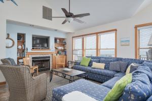 a living room with a blue couch and a fireplace at 7677 - Weathering Heights in Avon