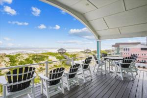 a porch with chairs and a table and a view of the beach at 5700 - La Cebolla in Nags Head