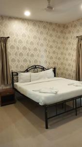 a bed with white sheets and pillows in a bedroom at Pool View Apartment - Sunshine By Leela Homes in Arpora