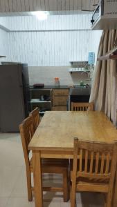 a kitchen with a wooden table and chairs at Pool View Apartment - Sunshine By Leela Homes in Arpora