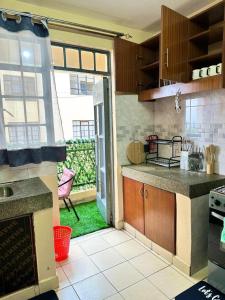 a kitchen with a view of a yard with a window at Executive two bedroom embu by Tsparks in Meru