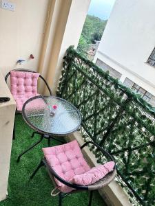 a balcony with a glass table and two chairs at Executive two bedroom embu by Tsparks in Meru