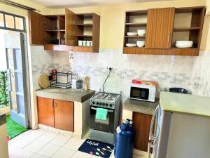 a kitchen with a stove and a microwave at Executive two bedroom embu by Tsparks in Meru +10 photos