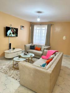 a living room with a couch and a table at Executive two bedroom embu by Tsparks in Meru