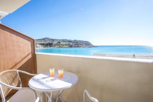 a table and chairs on a balcony with a view of the ocean at Charaki Rest Point in Haraki