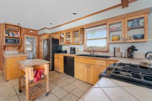 a kitchen with wooden cabinets and a black refrigerator at 7657 - Dragon's Lair in Avon
