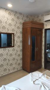 a bedroom with a wooden cabinet and a mirror at Pool View Apartment - Sunshine By Leela Homes in Arpora +2 photos