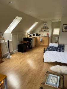 a large room with a bed and a kitchen at The Bird Loft Studio in Horsted Keynes