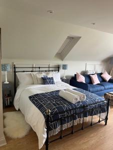 a bedroom with a bed and a blue couch at The Bird Loft Studio in Horsted Keynes