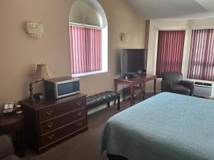 a hotel room with a bed and a flat screen tv at Lakeview Resort Motel in Wasaga Beach