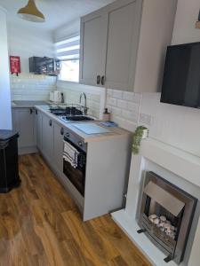 a kitchen with a fireplace in the middle of it at Savannah-by-the-sea in Bridlington