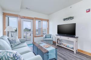 a living room with a couch and a tv at C103A - Sweet Sound Memories in Nags Head