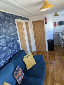 a living room with a blue couch and a kitchen at Savannah-by-the-sea in Bridlington +10 photos