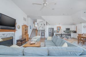 a living room with a blue couch and a fireplace at 4482 - Villa Al Mare in Duck