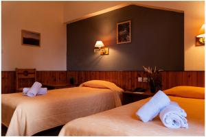 a hotel room with two beds with towels on them at Milionis Forest Hotel in Grevena