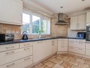 a kitchen with white cabinets and a sink at Thorntons House in Northallerton