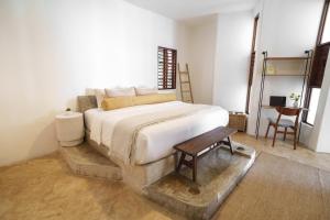 a bedroom with a large bed and a table at Mikasa Bacalar Hotel Boutique, Lagoon Front in Bacalar