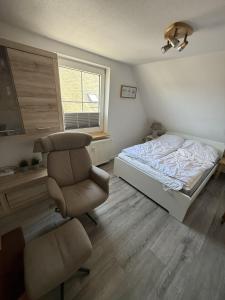 a bedroom with a bed and a chair at FeWo Heaven in Winterberg