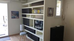 a room with a book shelf with a tv at Val Roya Terrasse, Penthouse avec terrasse panoramique au cœur de Nice, Quartier des Musiciens in Nice