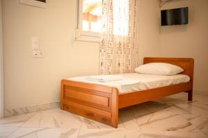 a small bed in a room with a window at Ektoras House in Platamonas