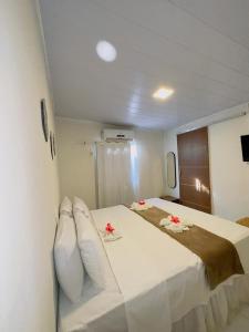 a bedroom with a large bed with white sheets and pillows at Pousada do Trinta in Fernando de Noronha