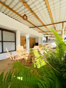 a large room with chairs and plants in it at Pousada do Trinta in Fernando de Noronha