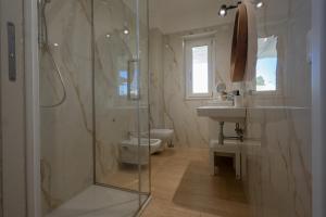 a bathroom with a shower and a toilet and a sink at Sinarca Elysium Apartment in Termoli