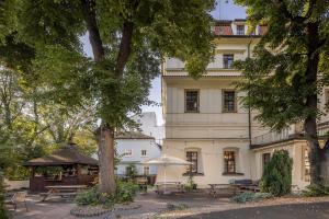 a building with tables and umbrellas in front of it at Pytloun Old Armoury Hotel Prague, Stará Zbrojnice in Prague