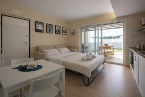a bedroom with a bed and a kitchen with a table at Sinarca Elysium Apartment in Termoli