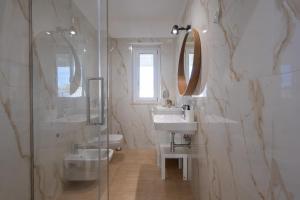 a white bathroom with a sink and a shower at Sinarca Elysium Apartment in Termoli +18 photos