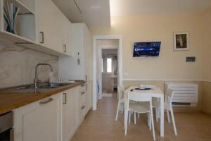 a kitchen with a table and a white table and chairs at Sinarca Elysium Apartment in Termoli