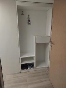 an empty closet with a door and some shoes in it at Srna apartmani in Čačak