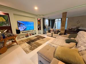 a living room with a couch and a flat screen tv at Villa Amarela in Itacimirim